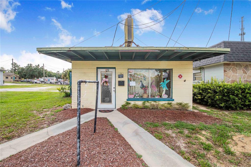 A small, single-story commercial building with a flat roof, a glass door, and a display window — 29 N 10TH STREET, HAINES CITY, FL