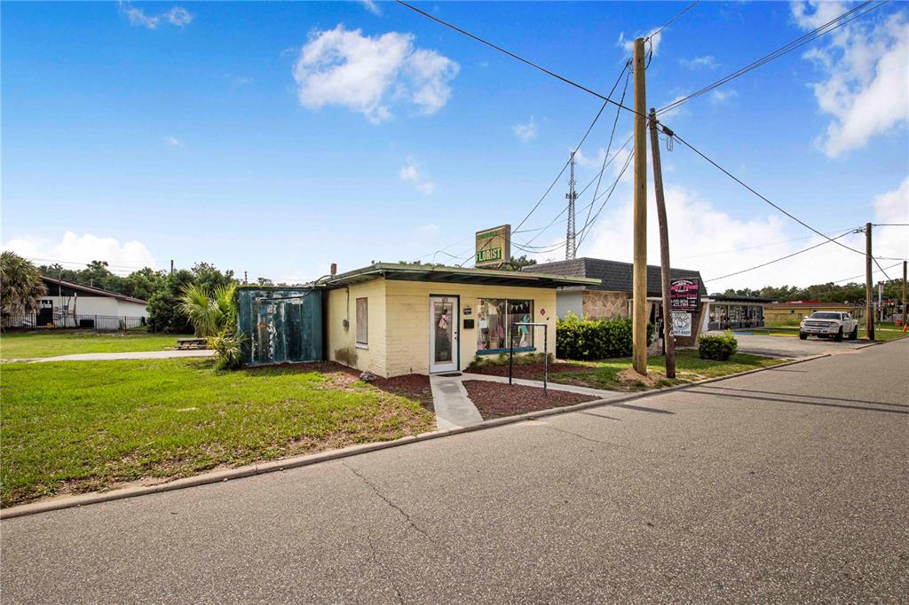 A small, yellow, single-story commercial building with a flat roof sits beside a paved road — 29 N 10TH STREET, HAINES CITY, FL
