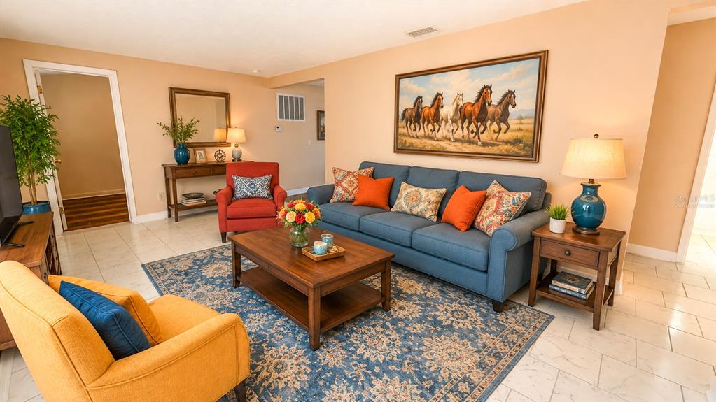 A living room features a blue sofa, a yellow armchair, and a coffee table — 4102 HIGHLAND LOOP, NEW PORT RICHEY, FL
