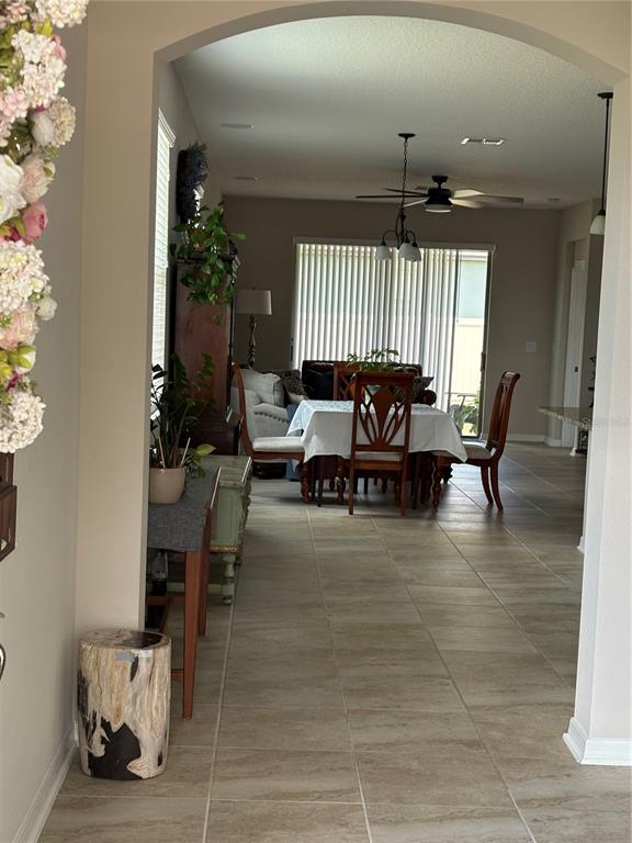 A dining area with a table and chairs is visible through an arched entryway — 17042 CRESTMONT BOULEVARD, CLERMONT, FL