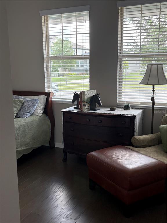 A bedroom features a wooden bed, a dark dresser with horse bookends, and a leather ottoman — 17042 CRESTMONT BOULEVARD, CLERMONT, FL