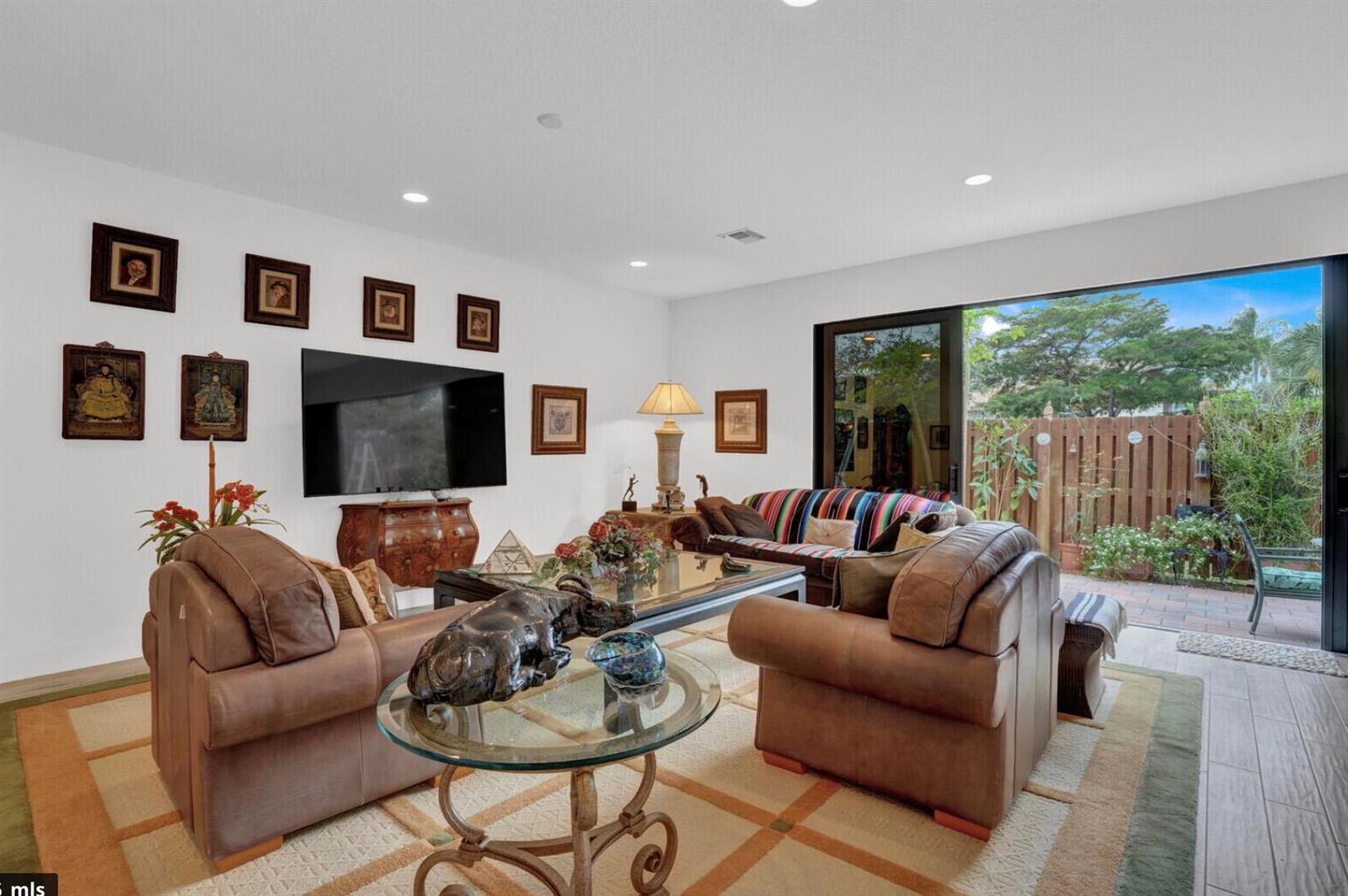 A living room features leather furniture, a glass coffee table, and a sliding door to a patio — 3199 Santa Catalina Place, FL 33467, FL