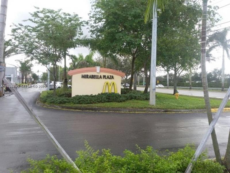 A sign for Mirabella Plaza stands in a landscaped area near a paved road — 2101 SW 101st Ave # 204, Miramar FL 33025, MIRAMAR, FL