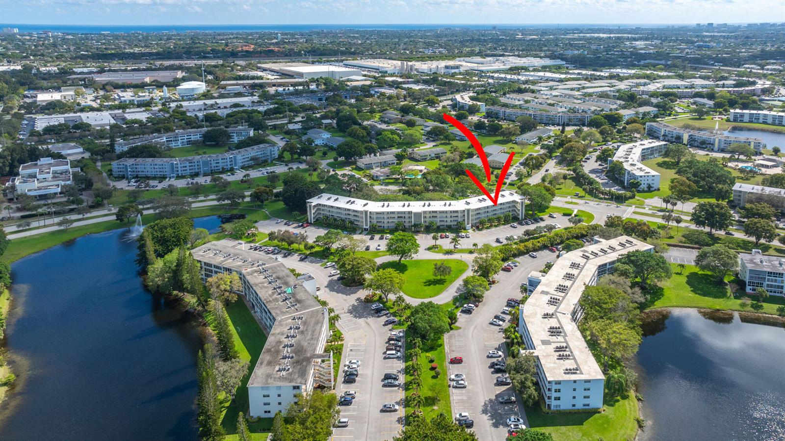 An aerial view shows a multi-story apartment building with a red arrow pointing toward it — 4002 Cambridge A # 4002, Deerfield Beach FL 33442, DEERFIELD BEACH, FL