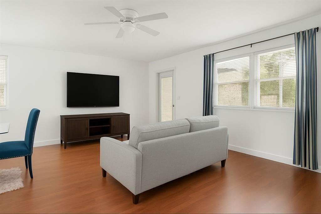 A living room features a gray sofa, a dark wood media console, and a television — 703 Brittany # O, Delray Beach FL 33446, DELRAY BEACH, FL