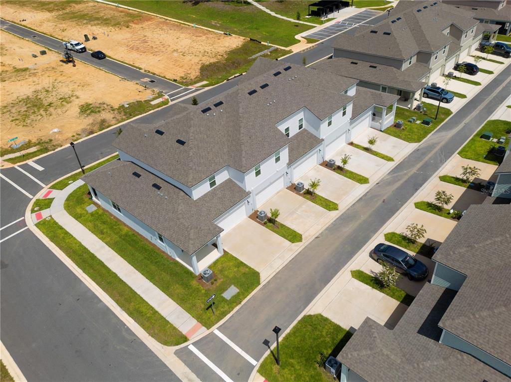 An aerial view shows a row of townhomes with attached garages and driveways — 104 ROYAL RANCH ROAD, GROVELAND, FL