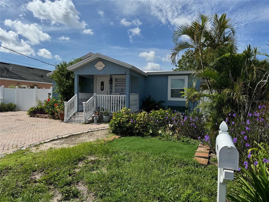 A blue house with a front porch, white railings, and a brick driveway — 3322 W SAINT JOSEPH STREET, TAMPA, FL