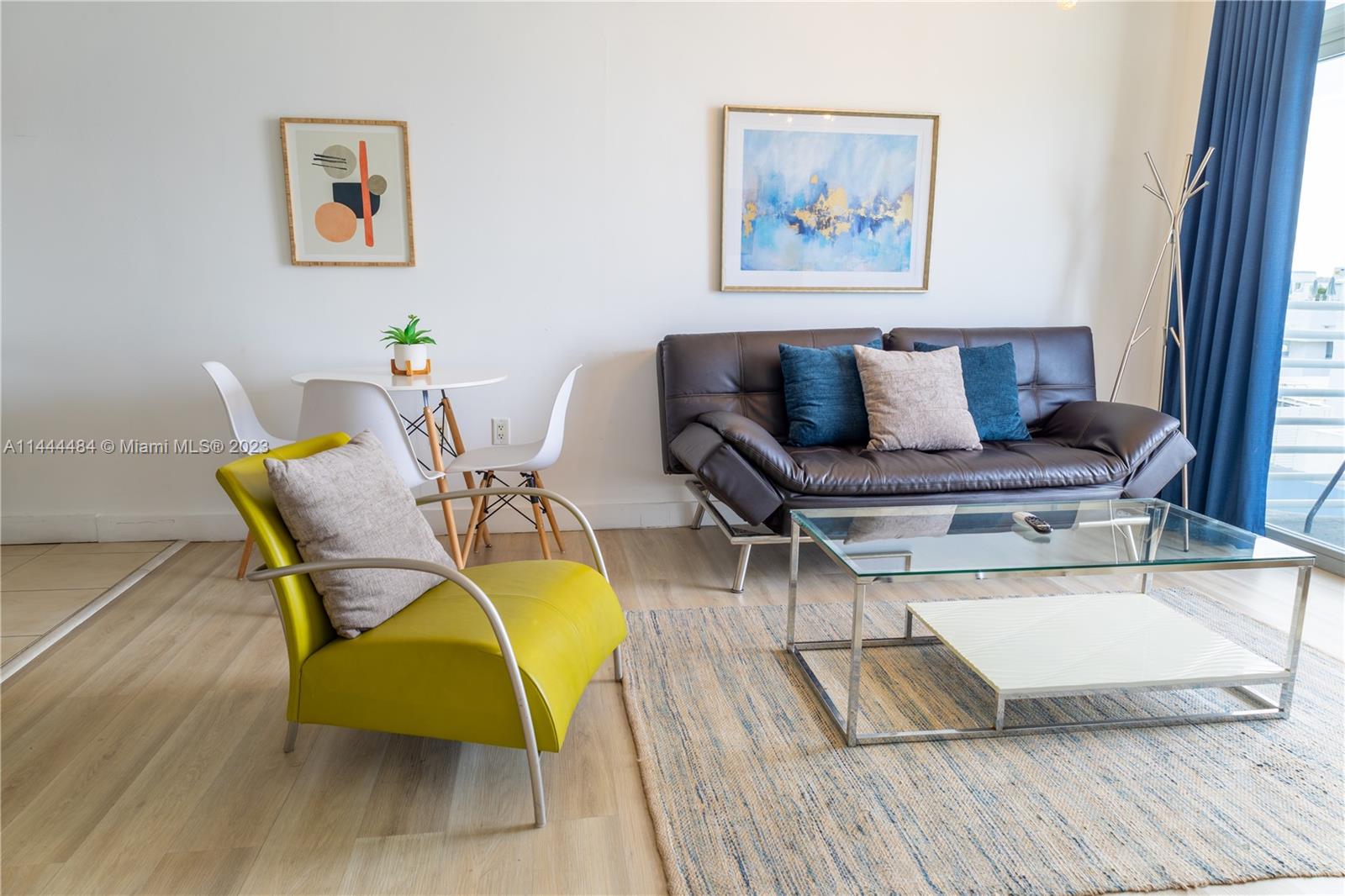 A living room features a dark sofa, a lime green armchair, and a glass coffee table — 1052 Ocean Dr # C503, Miami Beach FL 33139, MIAMI BEACH, FL