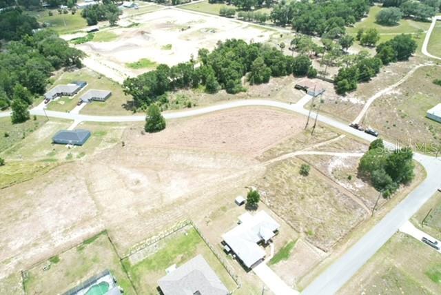 An aerial view shows a cleared residential lot surrounded by trees and nearby houses — LOCUST STREET, OCALA, FL