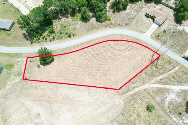 An aerial view shows a vacant, cleared lot outlined in red along a paved road — LOCUST STREET, OCALA, FL