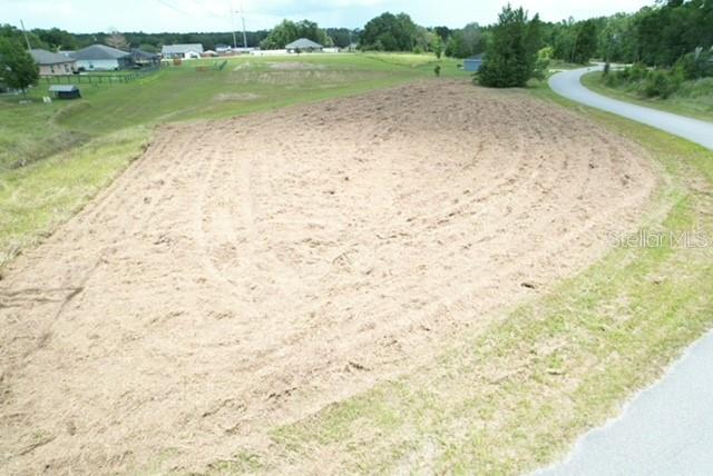 An elevated view of a cleared, vacant lot of land next to a paved road — LOCUST STREET, OCALA, FL