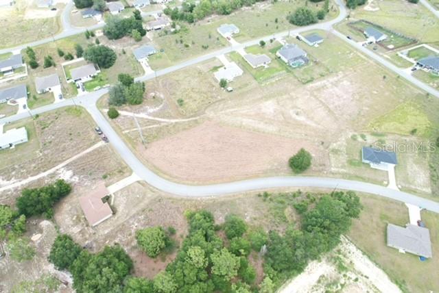 This aerial view shows a vacant residential lot situated along a curved paved road — LOCUST STREET, OCALA, FL