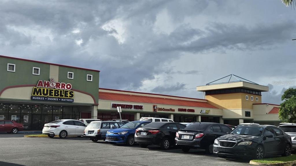 A strip mall features an Ahorro Muebles store, a parking lot, and several smaller retail businesses — 153 PR-153 KM 13.7, COAMO, PR