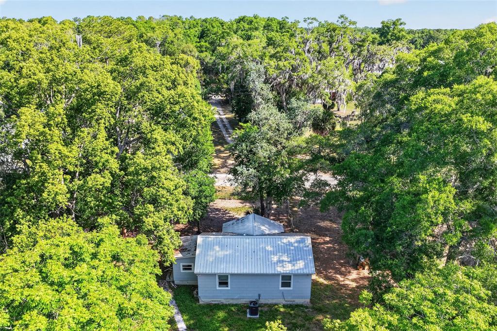 A weathered, single-story detached garage with a metal roof sits on a dirt lot — 6220 SE 118TH PLACE, BELLEVIEW, FL