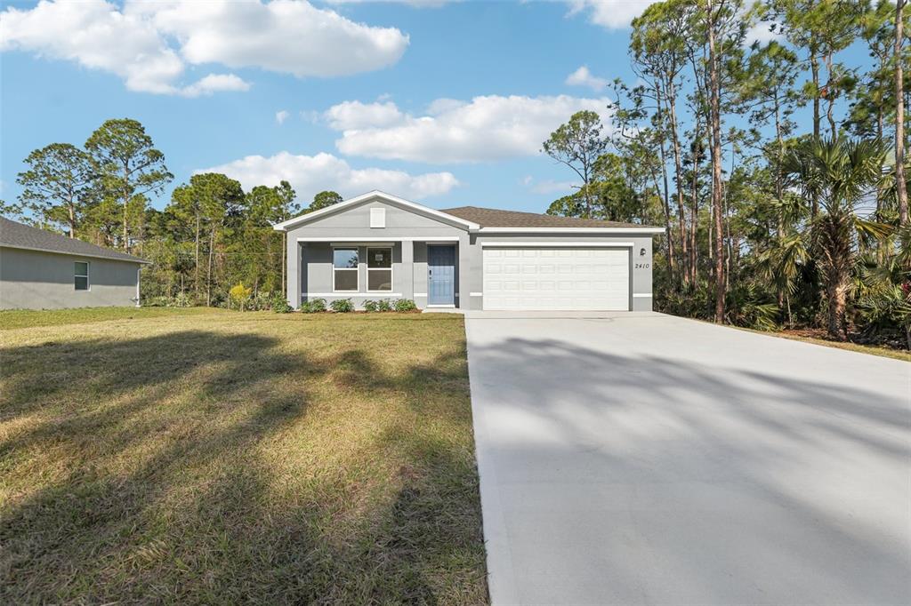 A single-story gray house with a blue front door and a concrete driveway — 3149 SANTA CRUZ AVENUE SE, PALM BAY, FL