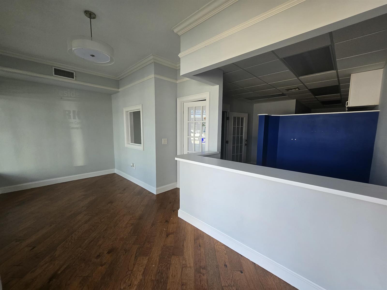 An interior view shows a room with hardwood floors, a service counter, and a blue wall — 38 SE Ocean Boulevard # 38, Stuart FL 34994, STUART, FL
