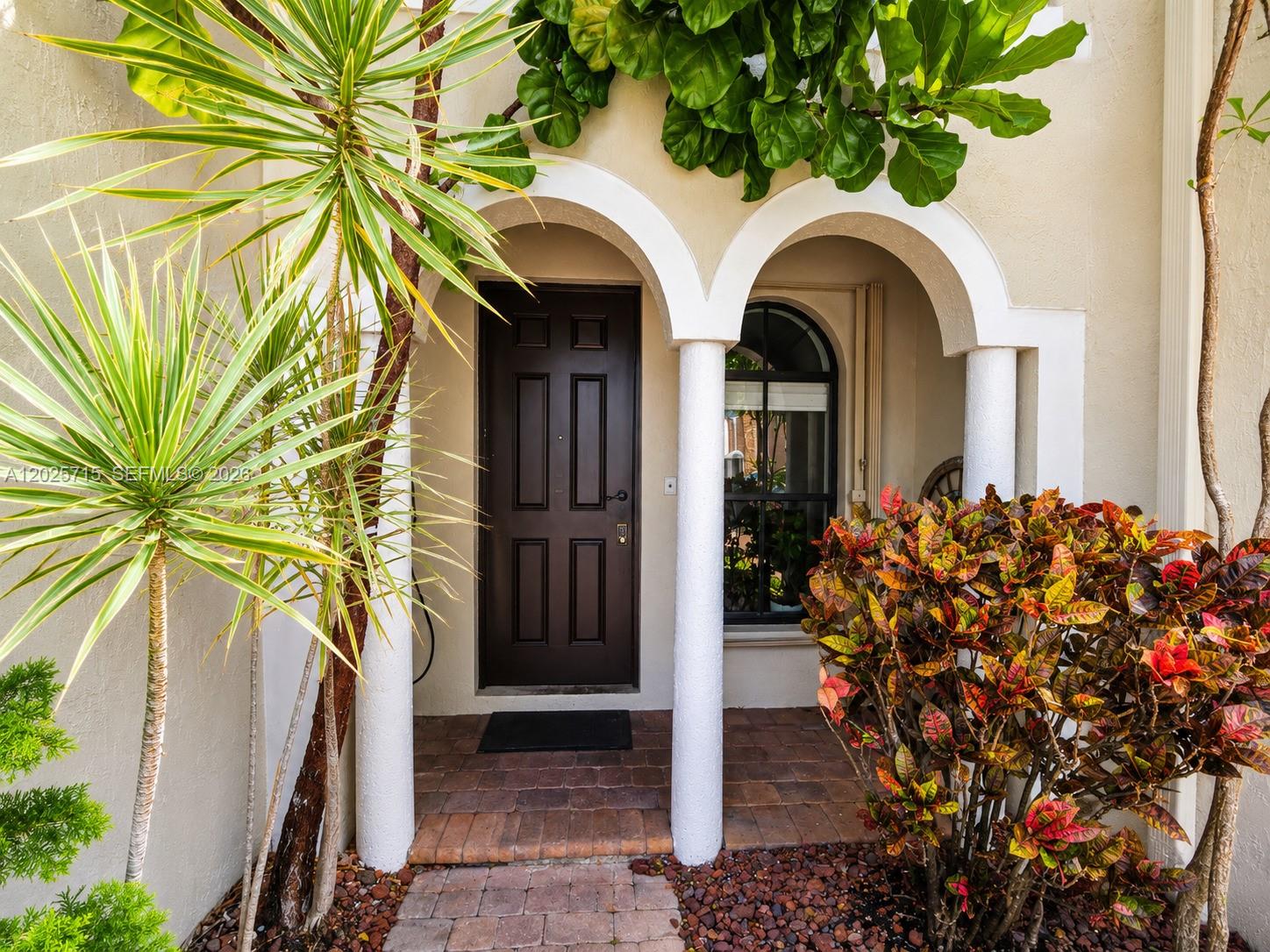 A brown front door is framed by two white columns and arched entryways — 3054 NW 103rd Path, Doral FL 33172, DORAL, FL