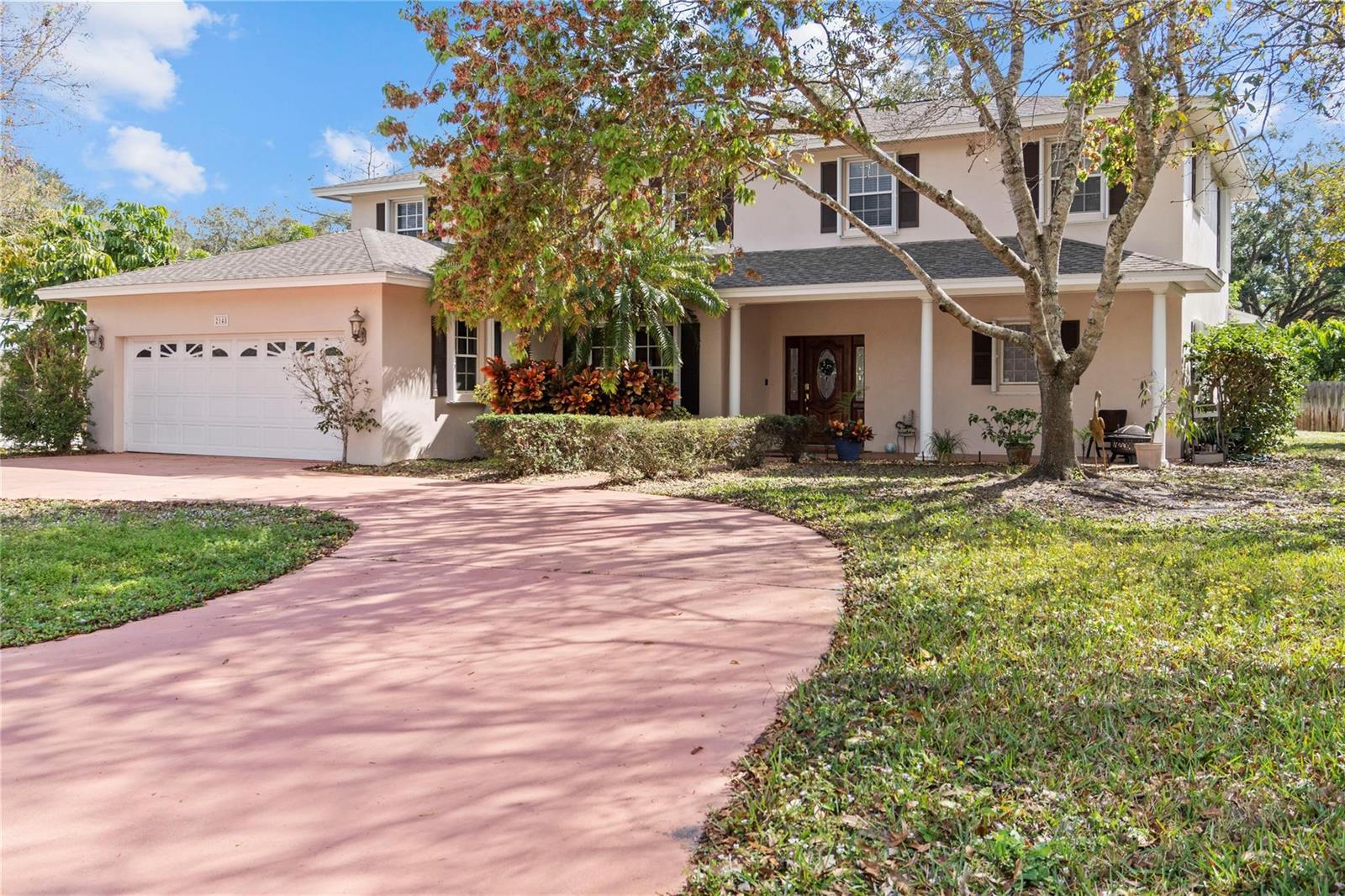 A two-story house with a beige exterior, a white garage, and a curved driveway — 2148 Buena Vista Boulevard, Vero Beach FL 32960, VERO BEACH, FL