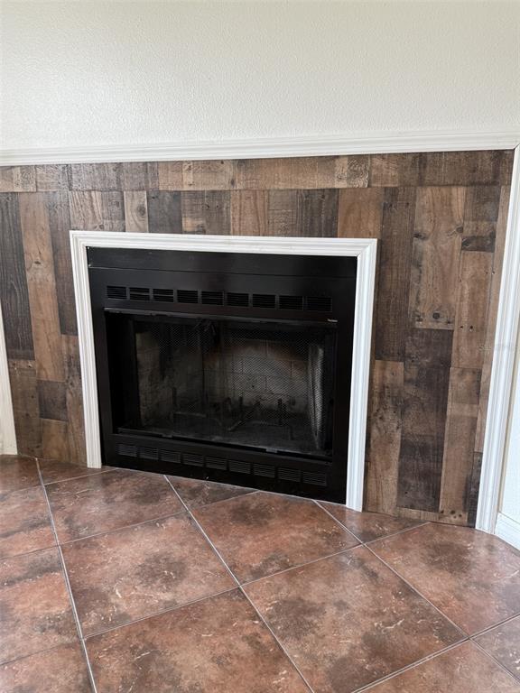 A fireplace with a rustic wood-plank surround and dark tile flooring — 7219 EDGEWATER SHORES COURT, ORLANDO, FL