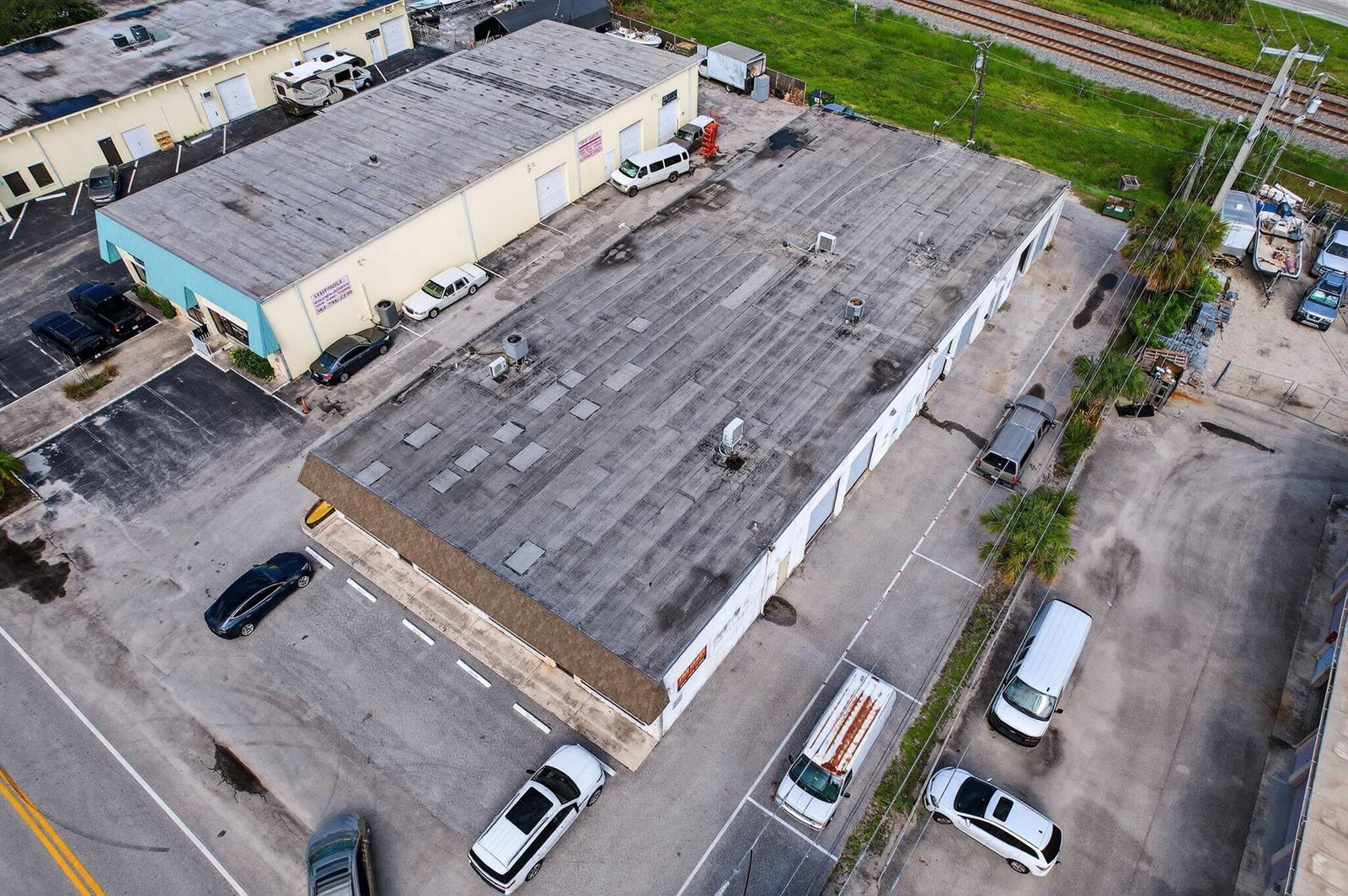 An aerial view shows two commercial warehouse buildings with parking lots and surrounding vehicles — 1460 S Cypress Drive # 9, Jupiter FL 33469, JUPITER, FL