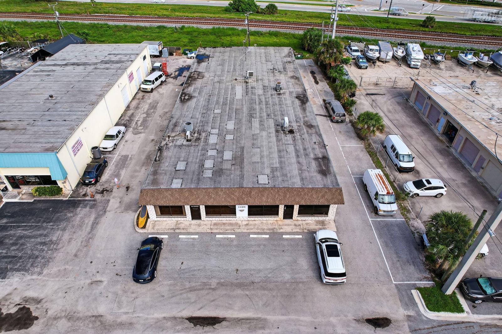 An aerial view shows a rectangular commercial building with a flat roof and surrounding parking lots — 1460 S Cypress Drive # 9, Jupiter FL 33469, JUPITER, FL