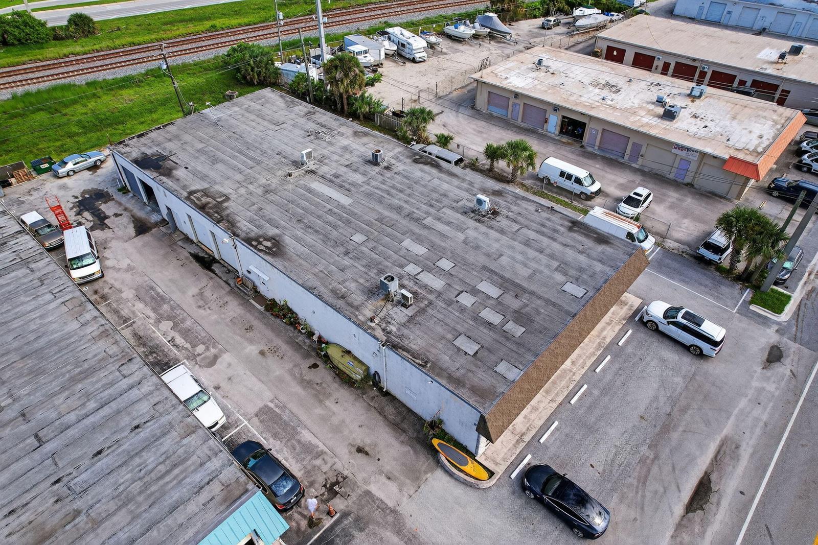 An aerial view shows a commercial building with a flat roof and surrounding parking lots — 1460 S Cypress Drive # 9, Jupiter FL 33469, JUPITER, FL