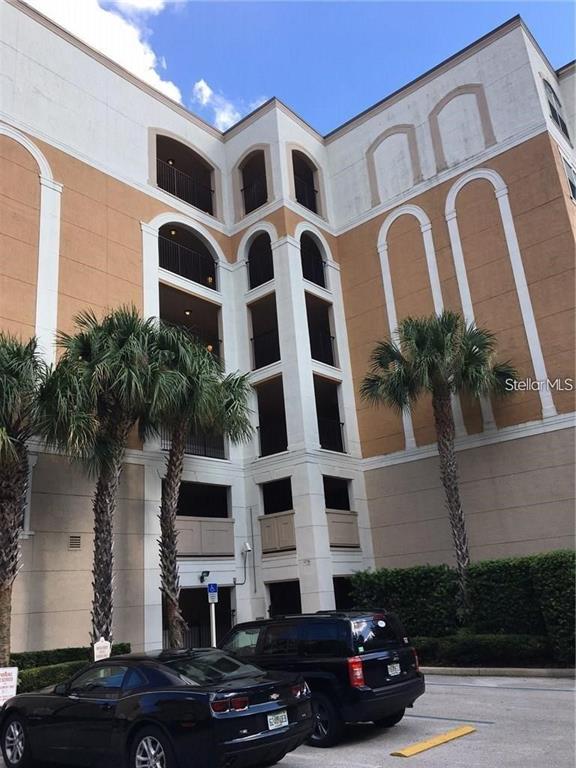 A multi-story building exterior features arched balconies, palm trees, and parked cars in front — 304 E SOUTH STREET UNIT 6025, ORLANDO, FL