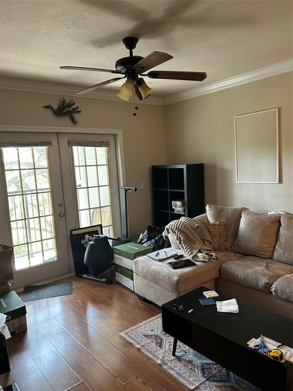 A living room features a ceiling fan, a sectional sofa, a coffee table, and French doors — 304 E SOUTH STREET UNIT 6025, ORLANDO, FL