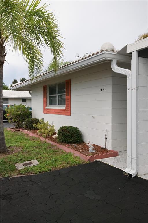 A white concrete block house with orange shutters and a palm tree in the front yard — 1741 CARIBBEAN CIRCLE UNIT 13, VENICE, FL