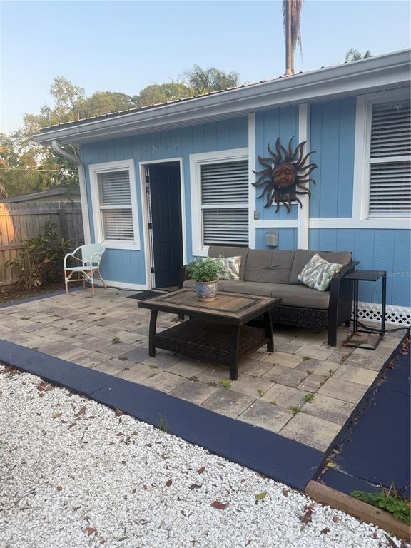 A blue house exterior features a paved patio with a sofa, coffee table, and chair — 2849 MARLETTE STREET, SARASOTA, FL
