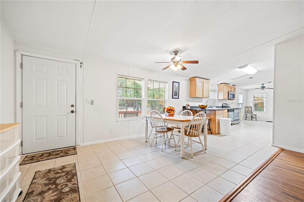 A dining area with a table and chairs sits adjacent to a kitchen with cabinets — 1366 SW CENTRAL TERRACE, FORT WHITE, FL