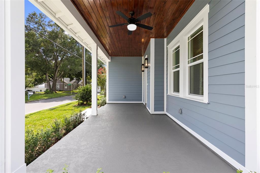 A covered front porch features a wood-paneled ceiling, a ceiling fan, and blue siding — 1224 E CHELSEA STREET, TAMPA, FL