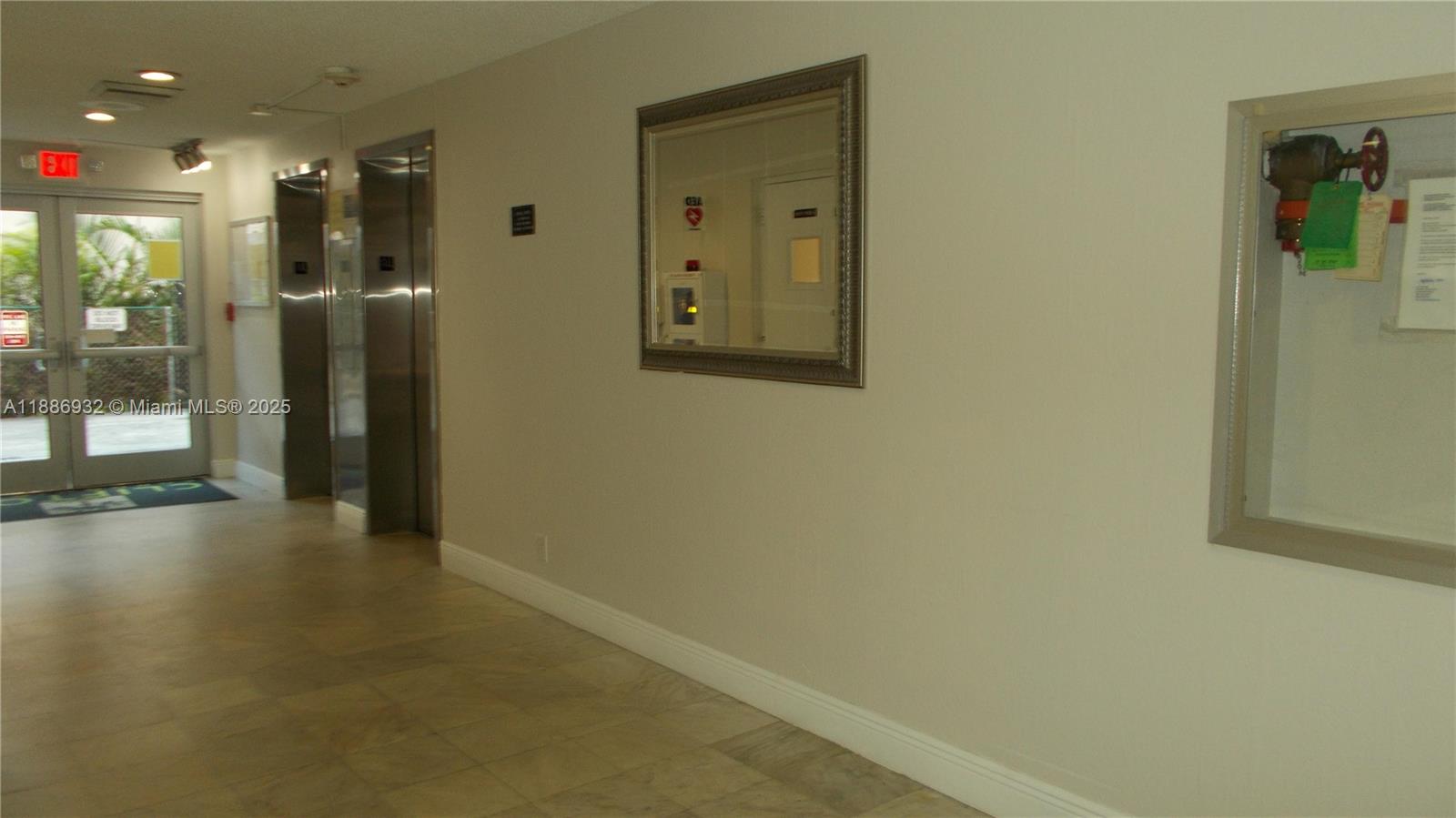 A hallway features a tiled floor, two elevators, a wall mirror, and a fire valve cabinet — 3161 S Ocean Dr # 505, Hallandale Beach FL 33009, HALLANDALE BEACH, FL