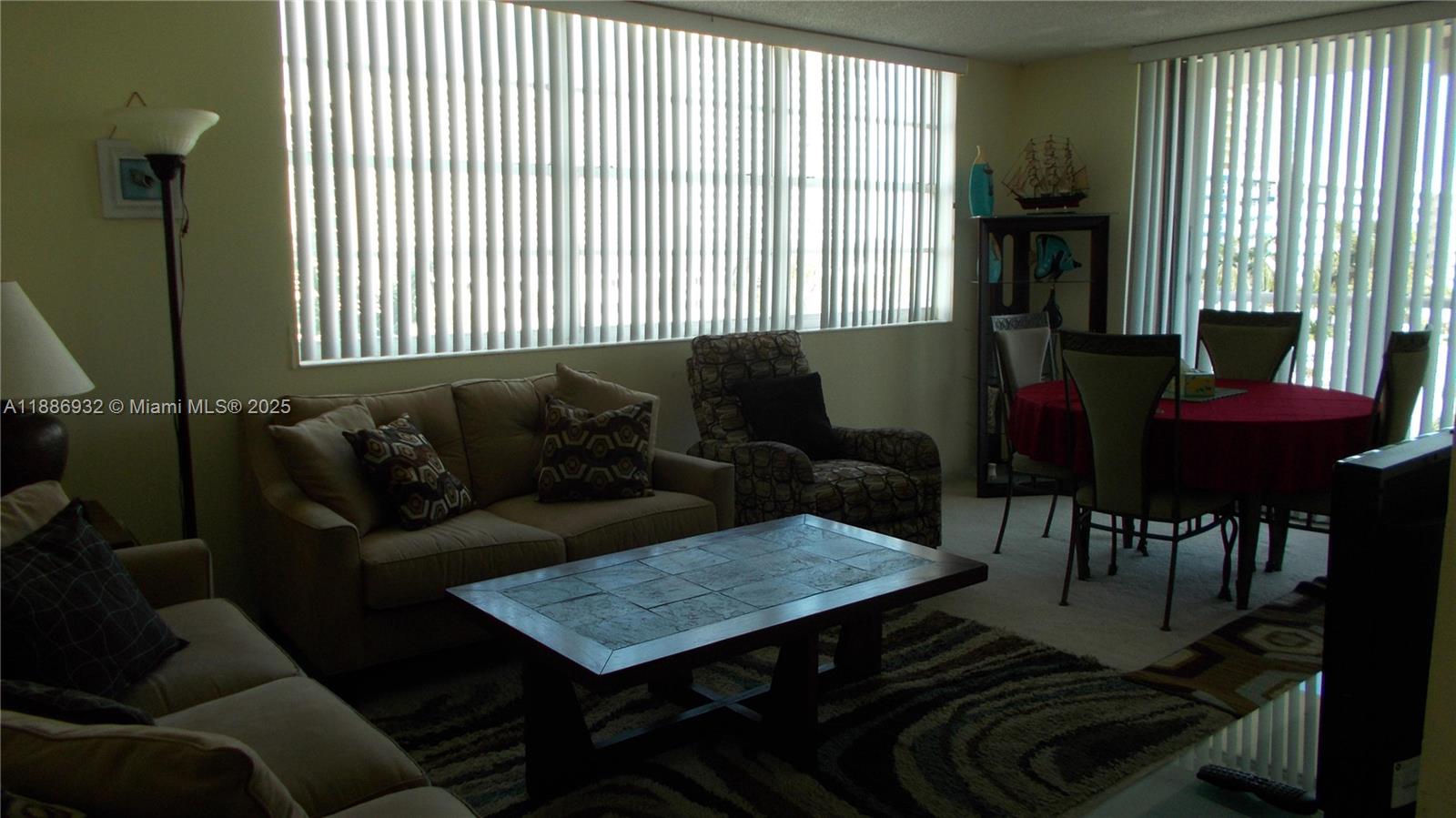 A living and dining area features a sofa, patterned armchair, coffee table, and round table — 3161 S Ocean Dr # 505, Hallandale Beach FL 33009, HALLANDALE BEACH, FL