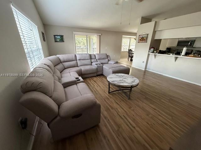 A living room features a large sectional sofa, a round coffee table, and wood-look flooring — 330 Sterling Drive, Winter Haven FL 33884, WINTER HAVEN, FL
