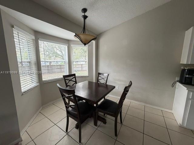 A dining area features a dark wood table, four chairs, tile flooring, and a pendant light — 330 Sterling Drive, Winter Haven FL 33884, WINTER HAVEN, FL
