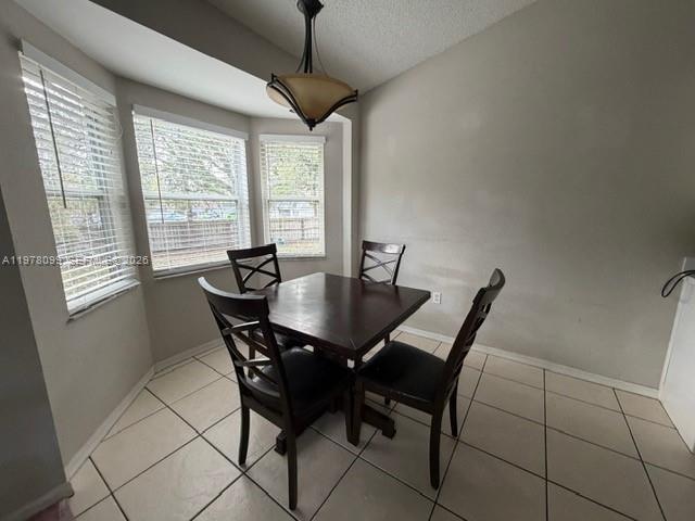 A dining area features a dark wood table with four chairs and a hanging light fixture — 330 Sterling Drive, Winter Haven FL 33884, WINTER HAVEN, FL