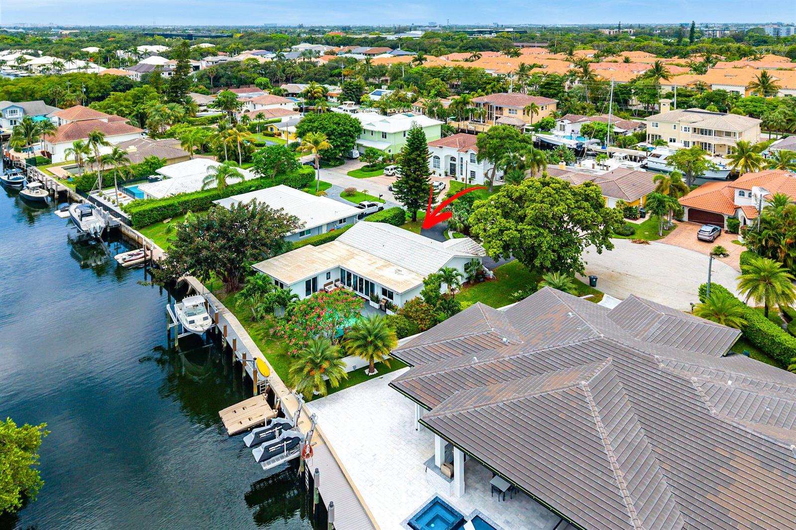 An aerial view shows a waterfront house with a pool and boat dock — 5660 Nassau Drive, Boca Raton FL 33487, BOCA RATON, FL