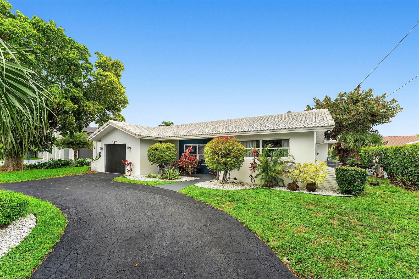 A single-story house with a white exterior, a tiled roof, and a curved asphalt driveway — 5660 Nassau Drive, Boca Raton FL 33487, BOCA RATON, FL