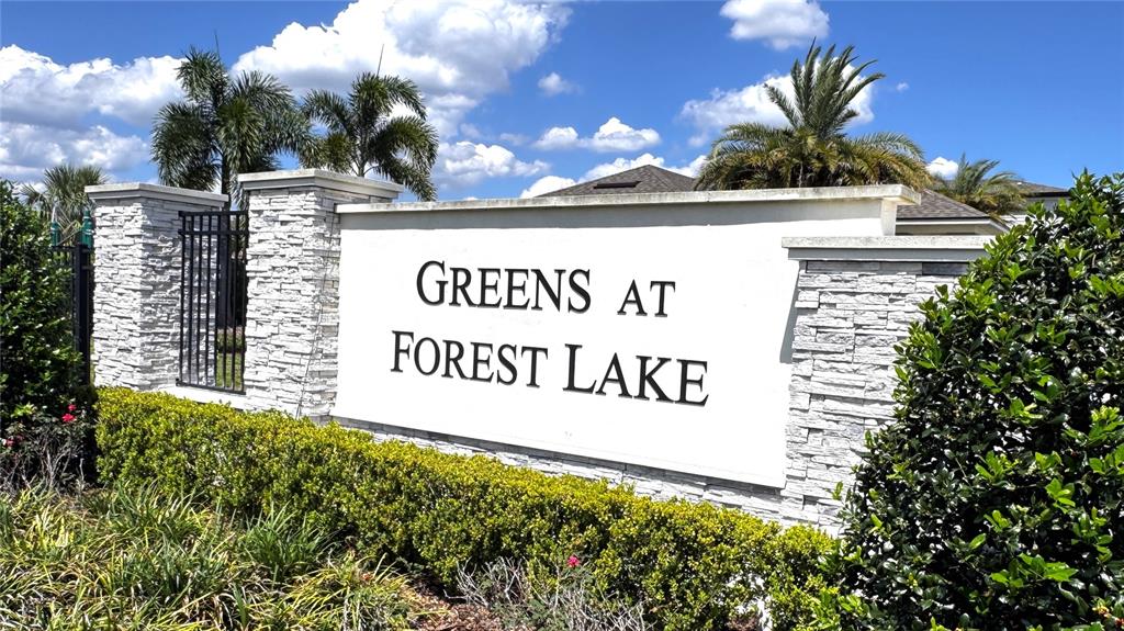 A stone-accented entrance sign for Greens at Forest Lake stands before palm trees and landscaping — 2463 SWEET VIBURNUM WAY, OCOEE, FL