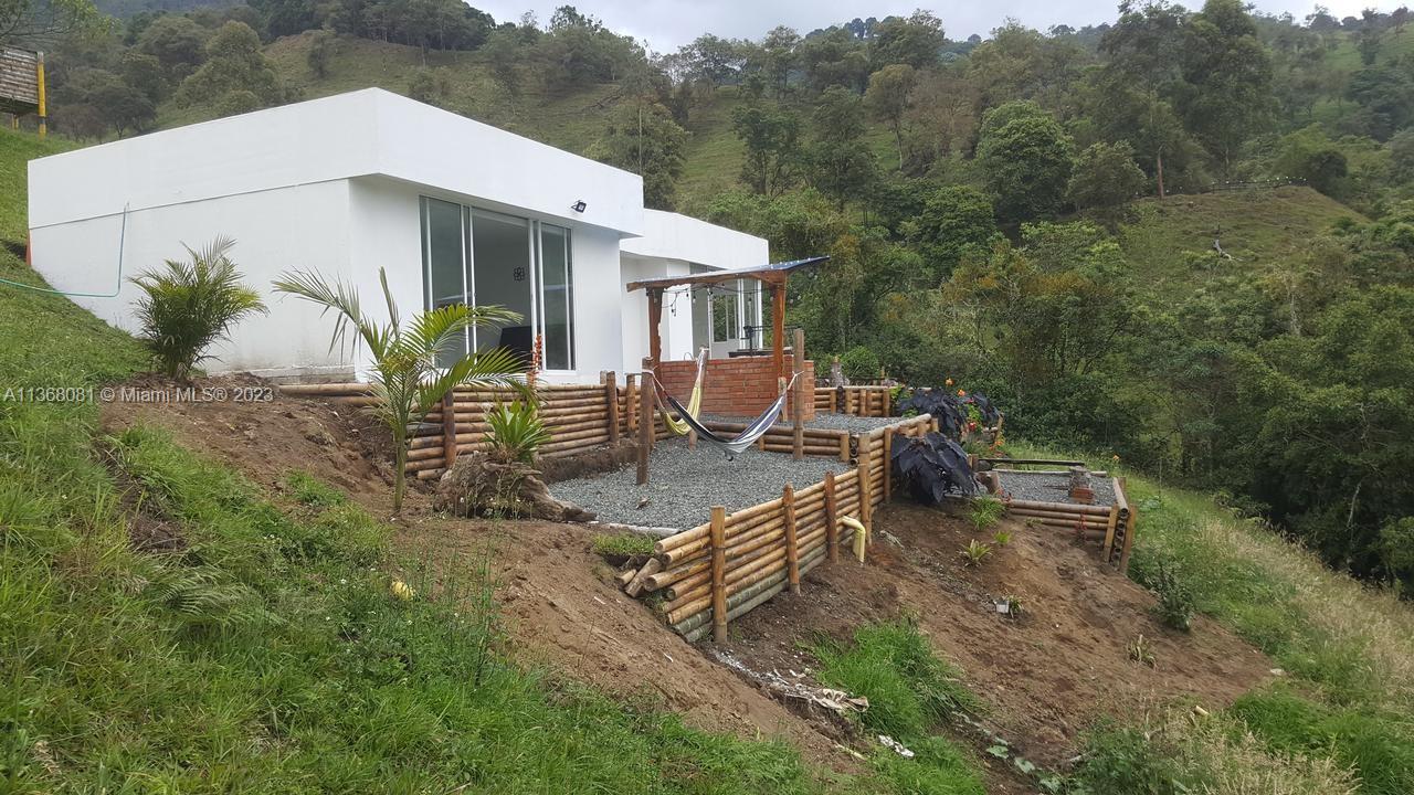 A modern white house sits on a hillside with a bamboo-retained gravel patio and hammock — Kilometro 4 Via Salento, Toche, Quindio, SA, SA