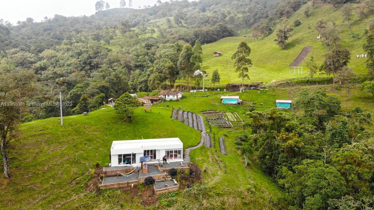 An aerial view shows a modern white house on a grassy hillside with agricultural plots — Kilometro 4 Via Salento, Toche, Quindio, SA, SA