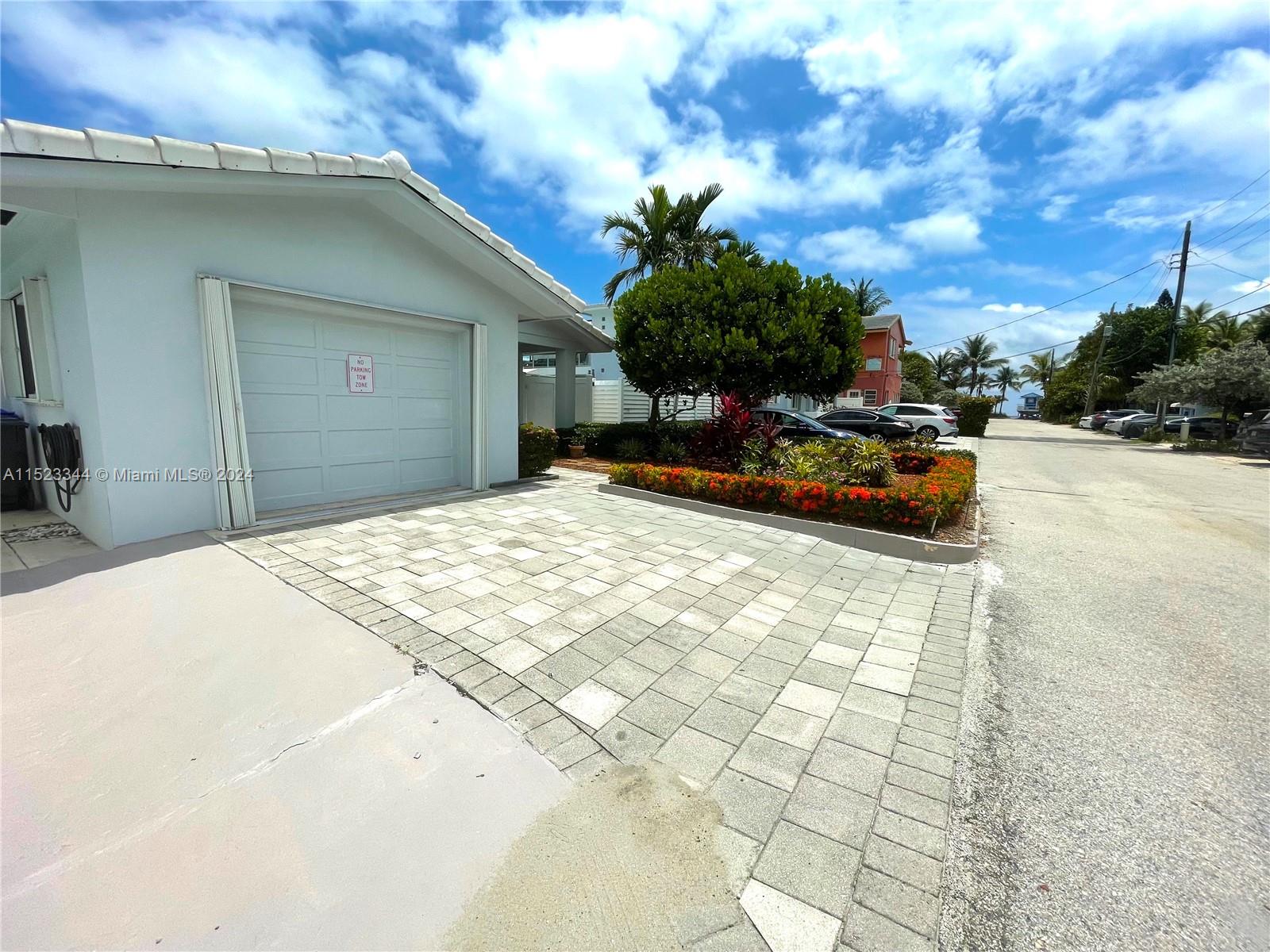 A light-colored house features a garage, a paved driveway, and a landscaped garden bed — 331 Desoto St, Hollywood FL 33019, HOLLYWOOD, FL
