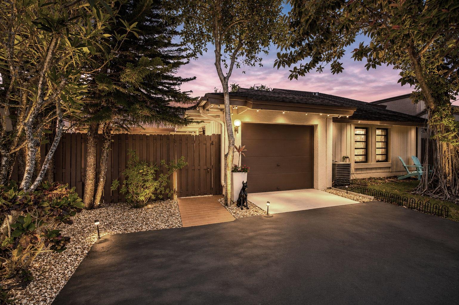 A single-story house exterior features a brown garage door, a wooden gate, and a driveway — 22602 Vistawood Way, Boca Raton FL 33428, BOCA RATON, FL
