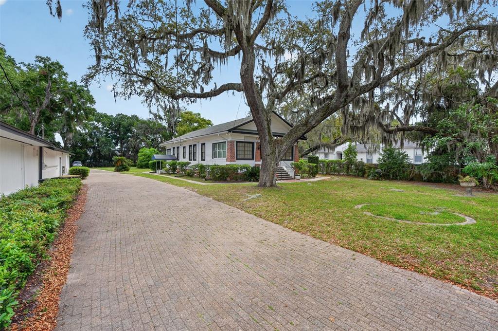 A paved driveway leads to a white house shaded by a large moss-draped oak tree — 4004 ATLANTIC BOULEVARD, JACKSONVILLE, FL