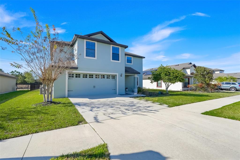 A two-story light blue house with a two-car garage and a concrete driveway — 5660 ELSINORE WAY, LAKELAND, FL