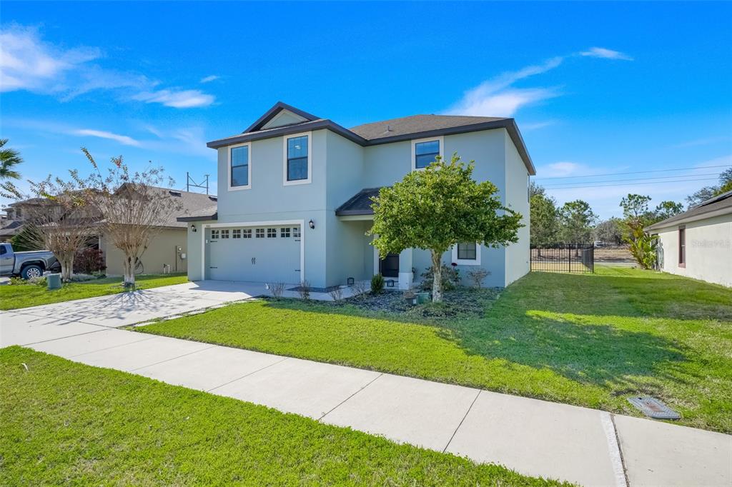 A two-story light blue house with a two-car garage and a front lawn — 5660 ELSINORE WAY, LAKELAND, FL