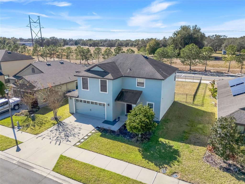 An aerial view of a two-story light blue house with a two-car garage — 5660 ELSINORE WAY, LAKELAND, FL