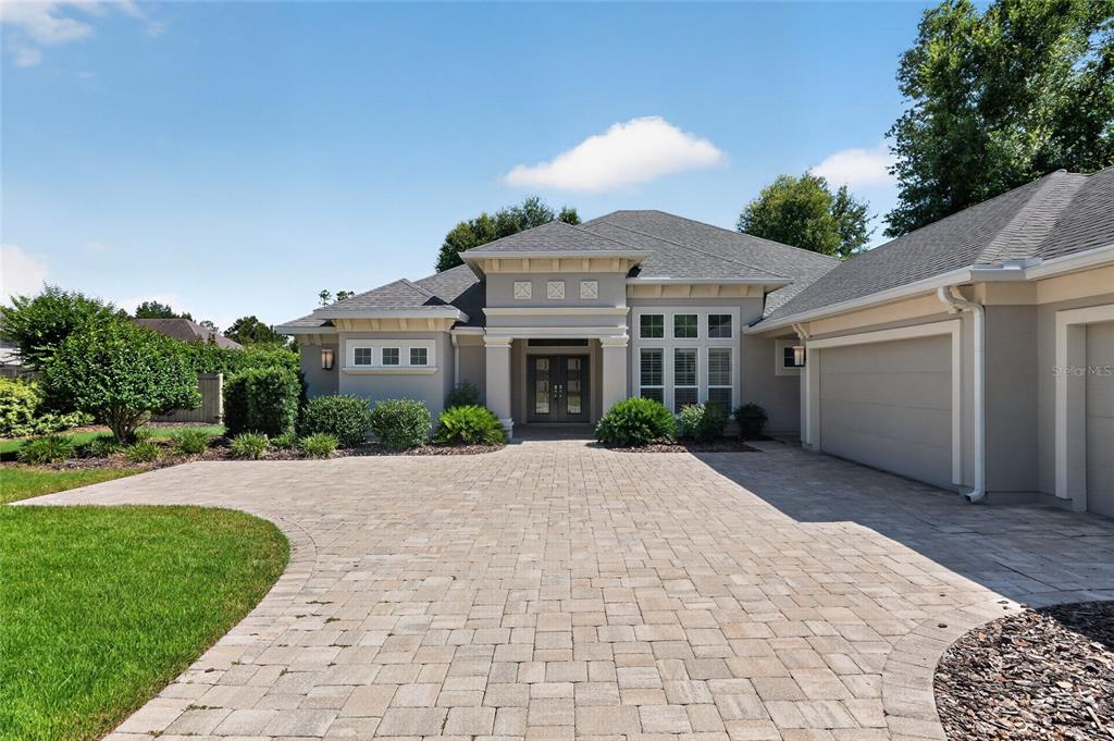 A single-story house with a paved driveway, a multi-car garage, and a central entryway — 10407 SW 26TH PLACE, GAINESVILLE, FL