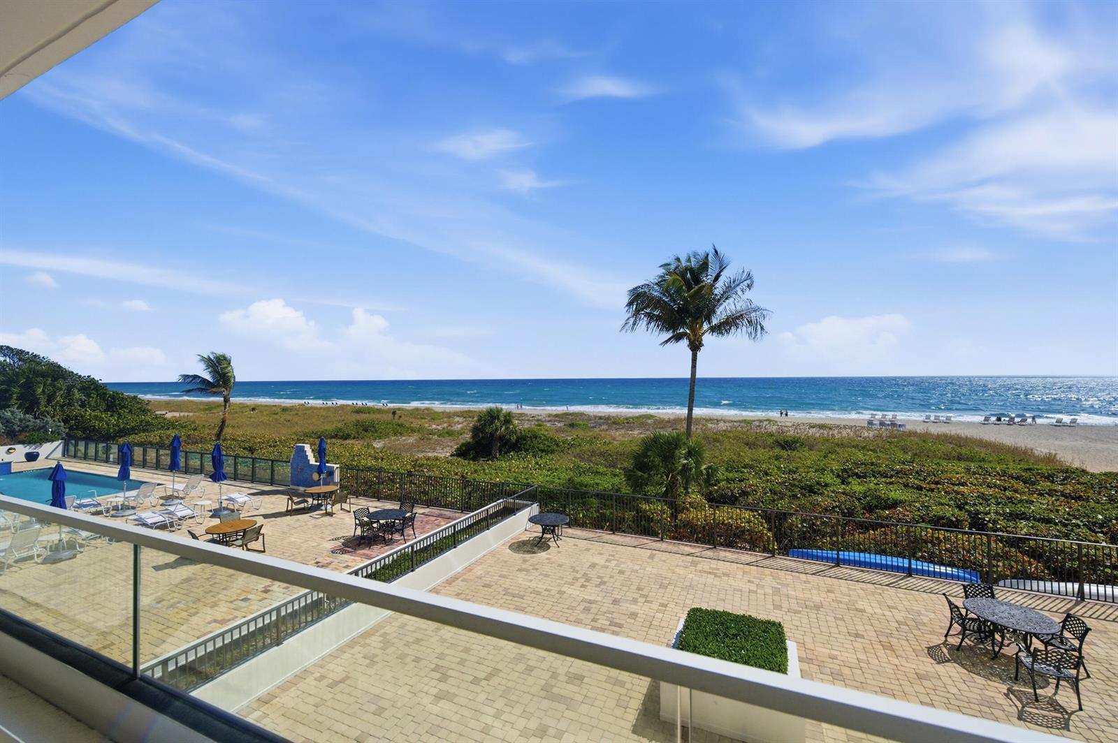 An elevated view of a paved patio with outdoor furniture overlooking a beach and ocean — 2800 S Ocean Boulevard # 2a, Boca Raton FL 33432, BOCA RATON, FL